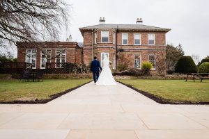 Bride and Groom walking in the garden at Shottle Hall Derbyshire